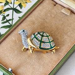 Vintage gold tone turtle brooch with green enamel shell and clear rhinestones, viewed from front and back.