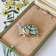 Vintage gold tone turtle brooch with green enamel shell and clear rhinestones, viewed from front and back.