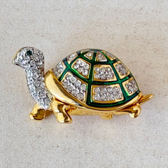 Vintage gold tone turtle brooch with green enamel shell and clear rhinestones, viewed from front and back.