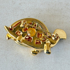 Vintage gold tone turtle brooch with green enamel shell and clear rhinestones, viewed from front and back.