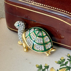 Vintage gold tone turtle brooch with green enamel shell and clear rhinestones, viewed from front and back.