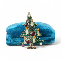 Vintage 1950s Christmas tree brooch with green, red, amber, and clear rhinestones in a gold tone setting, featuring five candle-like stones and a teardrop topper; unsigned Weiss style, very good condition.
