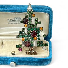 Vintage 1950s Christmas tree brooch with green, red, amber, and clear rhinestones in a gold tone setting, featuring five candle-like stones and a teardrop topper; unsigned Weiss style, very good condition.
