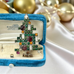 Vintage 1950s Christmas tree brooch with green, red, amber, and clear rhinestones in a gold tone setting, featuring five candle-like stones and a teardrop topper; unsigned Weiss style, very good condition.