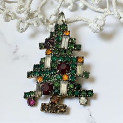 Vintage 1950s Christmas tree brooch with green, red, amber, and clear rhinestones in a gold tone setting, featuring five candle-like stones and a teardrop topper; unsigned Weiss style, very good condition.