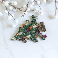 Vintage 1950s Christmas tree brooch with green, red, amber, and clear rhinestones in a gold tone setting, featuring five candle-like stones and a teardrop topper; unsigned Weiss style, very good condition.