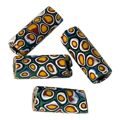 A set of vintage Venetian millefiori African trade beads in vibrant green and yellow. The tube-shaped glass beads, originating from Ghana, feature intricate floral patterns and showcase the rich history of 19th and 20th-century trade. Some beads show minor chips due to age, adding to their authentic vintage charm