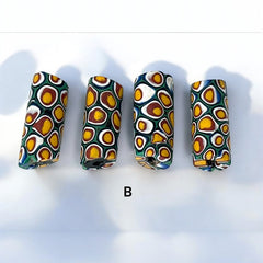 A set of vintage Venetian millefiori African trade beads in vibrant green and yellow. The tube-shaped glass beads, originating from Ghana, feature intricate floral patterns and showcase the rich history of 19th and 20th-century trade. Some beads show minor chips due to age, adding to their authentic vintage charm.