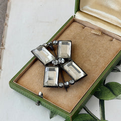 Vintage Victorian silver‑tone bow brooch with emerald‑cut clear glass stones and paste rhinestones, shown from multiple angles highlighting its antique patina and craftsmanship.