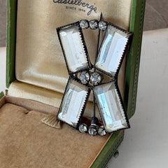 Vintage Victorian silver‑tone bow brooch with emerald‑cut clear glass stones and paste rhinestones, shown from multiple angles highlighting its antique patina and craftsmanship.