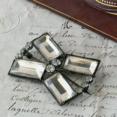 Vintage Victorian silver‑tone bow brooch with emerald‑cut clear glass stones and paste rhinestones, shown from multiple angles highlighting its antique patina and craftsmanship.