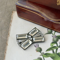 Vintage Victorian silver‑tone bow brooch with emerald‑cut clear glass stones and paste rhinestones, shown from multiple angles highlighting its antique patina and craftsmanship.
