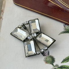Vintage Victorian silver‑tone bow brooch with emerald‑cut clear glass stones and paste rhinestones, shown from multiple angles highlighting its antique patina and craftsmanship.