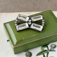 Vintage Victorian silver‑tone bow brooch with emerald‑cut clear glass stones and paste rhinestones, shown from multiple angles highlighting its antique patina and craftsmanship.