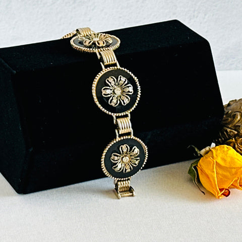 Vintage Victorian Revival gold‑tone bracelet with round black disks, filigree floral overlays, and clear rhinestone centers shown in various angles and styling arrangements.