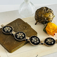 Vintage Victorian Revival gold‑tone bracelet with round black disks, filigree floral overlays, and clear rhinestone centers shown in various angles and styling arrangements.