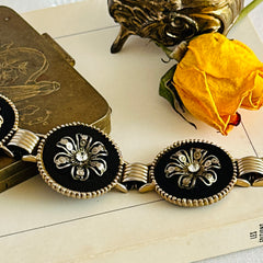 Vintage Victorian Revival gold‑tone bracelet with round black disks, filigree floral overlays, and clear rhinestone centers shown in various angles and styling arrangements.