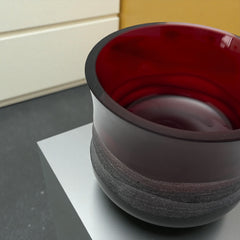 Vintage Villeroy & Boch ruby red glass vase with modernist etched pattern, shown on a neutral surface. The low, wide silhouette and translucent red hue evoke sculptural elegance, with geometric etching wrapping around the bowl. Signed on the underside, this French glass piece reflects 1980s–1990s design clarity