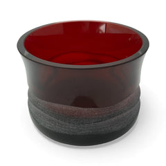 Vintage Villeroy & Boch ruby red glass vase with modernist etched pattern, shown on a neutral surface. The low, wide silhouette and translucent red hue evoke sculptural elegance, with geometric etching wrapping around the bowl. Signed on the underside, this French glass piece reflects 1980s–1990s design clarity