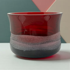 Vintage Villeroy & Boch ruby red glass vase with modernist etched pattern, shown on a neutral surface. The low, wide silhouette and translucent red hue evoke sculptural elegance, with geometric etching wrapping around the bowl. Signed on the underside, this French glass piece reflects 1980s–1990s design clarity