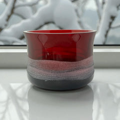 Vintage Villeroy & Boch ruby red glass vase with modernist etched pattern, shown on a neutral surface. The low, wide silhouette and translucent red hue evoke sculptural elegance, with geometric etching wrapping around the bowl. Signed on the underside, this French glass piece reflects 1980s–1990s design clarity
