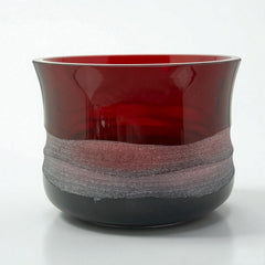 Vintage Villeroy & Boch ruby red glass vase with modernist etched pattern, shown on a neutral surface. The low, wide silhouette and translucent red hue evoke sculptural elegance, with geometric etching wrapping around the bowl. Signed on the underside, this French glass piece reflects 1980s–1990s design clarity