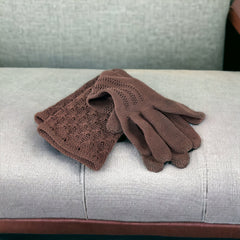 Vintage medium-length brown cotton gloves with a raised knit pattern on the arm and back of the hand, gently worn and in very good condition, laid flat to show texture and detail.