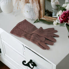 Vintage medium-length brown cotton gloves with a raised knit pattern on the arm and back of the hand, gently worn and in very good condition, laid flat to show texture and detail.