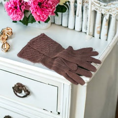 Vintage medium-length brown cotton gloves with a raised knit pattern on the arm and back of the hand, gently worn and in very good condition, laid flat to show texture and detail.
