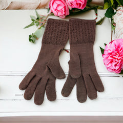 Vintage medium-length brown cotton gloves with a raised knit pattern on the arm and back of the hand, gently worn and in very good condition, laid flat to show texture and detail.