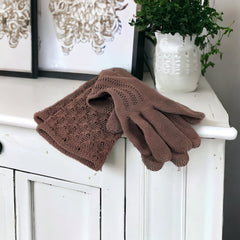 Vintage medium-length brown cotton gloves with a raised knit pattern on the arm and back of the hand, gently worn and in very good condition, laid flat to show texture and detail.