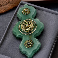 Vintage Vogue Bijoux green resin statement brooch with gold‑tone floral motifs and clear rhinestones.