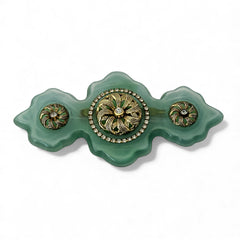 Vintage Vogue Bijoux green resin statement brooch with gold‑tone floral motifs and clear rhinestones.