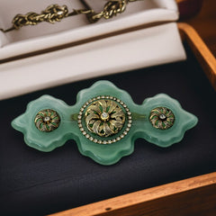Vintage Vogue Bijoux green resin statement brooch with gold‑tone floral motifs and clear rhinestones.