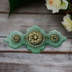Vintage Vogue Bijoux green resin statement brooch with gold‑tone floral motifs and clear rhinestones.