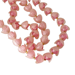 Vintage 1950s West Germany double-strand necklace displayed on black velvet stand, featuring frosted pink plastic petal beads encasing darker pink faceted centers, finished with a round pink cabochon clasp.