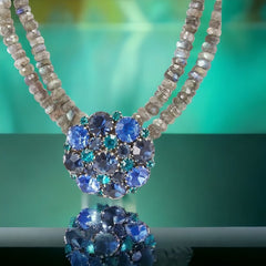  A stunning vintage Weiss crystal dome brooch in shades of blue and teal, paired with a double strand of shiny blue and gray faceted labradorite rondelles. The brooch can be worn centered, off-center, or separately, offering versatile styling. Finished with sterling silver spacers and a toggle clasp, this unique piece blends vintage charm with modern craftsmanship, signed Weiss on the back and featuring the EM tag in Etruscan alphabet for Elisabeth Michel-Meyrueix.

