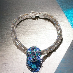 A stunning vintage Weiss crystal dome brooch in shades of blue and teal, paired with a double strand of shiny blue and gray faceted labradorite rondelles. The brooch can be worn centered, off-center, or separately, offering versatile styling. Finished with sterling silver spacers and a toggle clasp, this unique piece blends vintage charm with modern craftsmanship, signed Weiss on the back and featuring the EM tag in Etruscan alphabet for Elisabeth Michel-Meyrueix.
