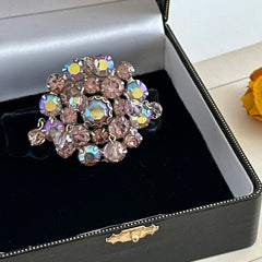 Vintage 1950s Weiss round brooch with light amethyst and amethyst AB rhinestones arranged in a layered cluster, set in rhodium‑plated metal with a dangling bead accent