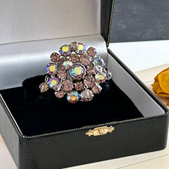 Vintage 1950s Weiss round brooch with light amethyst and amethyst AB rhinestones arranged in a layered cluster, set in rhodium‑plated metal with a dangling bead accent