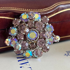 Vintage 1950s Weiss round brooch with light amethyst and amethyst AB rhinestones arranged in a layered cluster, set in rhodium‑plated metal with a dangling bead accent