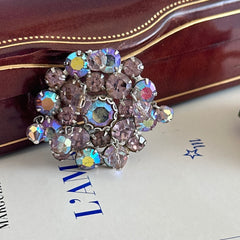 Vintage 1950s Weiss round brooch with light amethyst and amethyst AB rhinestones arranged in a layered cluster, set in rhodium‑plated metal with a dangling bead accent
