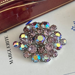 Vintage 1950s Weiss round brooch with light amethyst and amethyst AB rhinestones arranged in a layered cluster, set in rhodium‑plated metal with a dangling bead accent