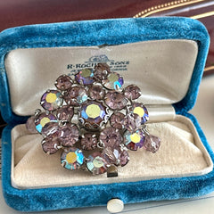 Vintage 1950s Weiss round brooch with light amethyst and amethyst AB rhinestones arranged in a layered cluster, set in rhodium‑plated metal with a dangling bead accent