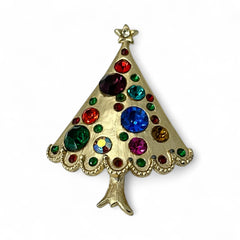 Vintage gold-tone Christmas tree brooch with multicolor rhinestones and scalloped edges, featuring a star at the top and textured detailing; back view shows pin clasp and trunk-shaped base, typical of 1980s–1990s holiday jewelry.