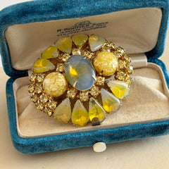 Vintage gold‑tone brooch with blue‑gray givre cabochon, yellow givre teardrops, confetti Lucite cabochons, and yellow chaton rhinestones.