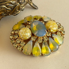 Vintage gold‑tone brooch with blue‑gray givre cabochon, yellow givre teardrops, confetti Lucite cabochons, and yellow chaton rhinestones.