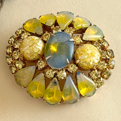Vintage gold‑tone brooch with blue‑gray givre cabochon, yellow givre teardrops, confetti Lucite cabochons, and yellow chaton rhinestones.