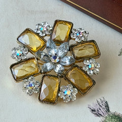 Vintage gold‑tone floral brooch with yellow emerald‑cut rhinestones and clear AB rhinestone clusters.