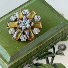 Vintage gold‑tone floral brooch with yellow emerald‑cut rhinestones and clear AB rhinestone clusters.